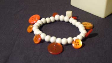 bracelet blanc et boutons oranges